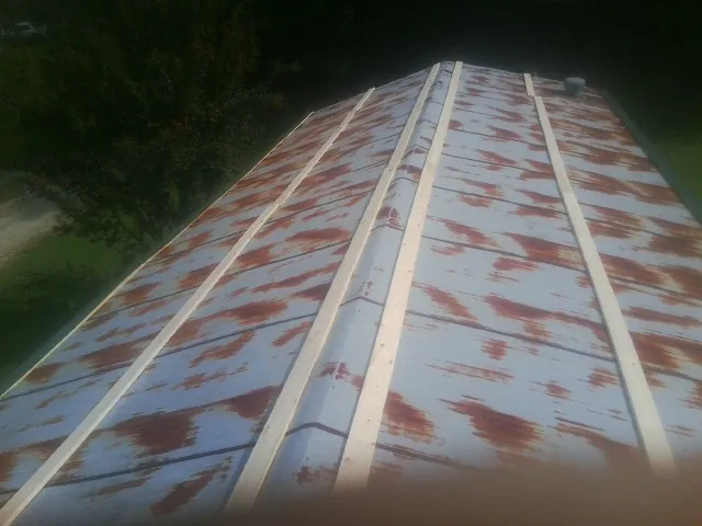Rusted metal roof panels with new wood purlins before replacement — Storm Damage Roof Repair in Burley by Roofing Brothers