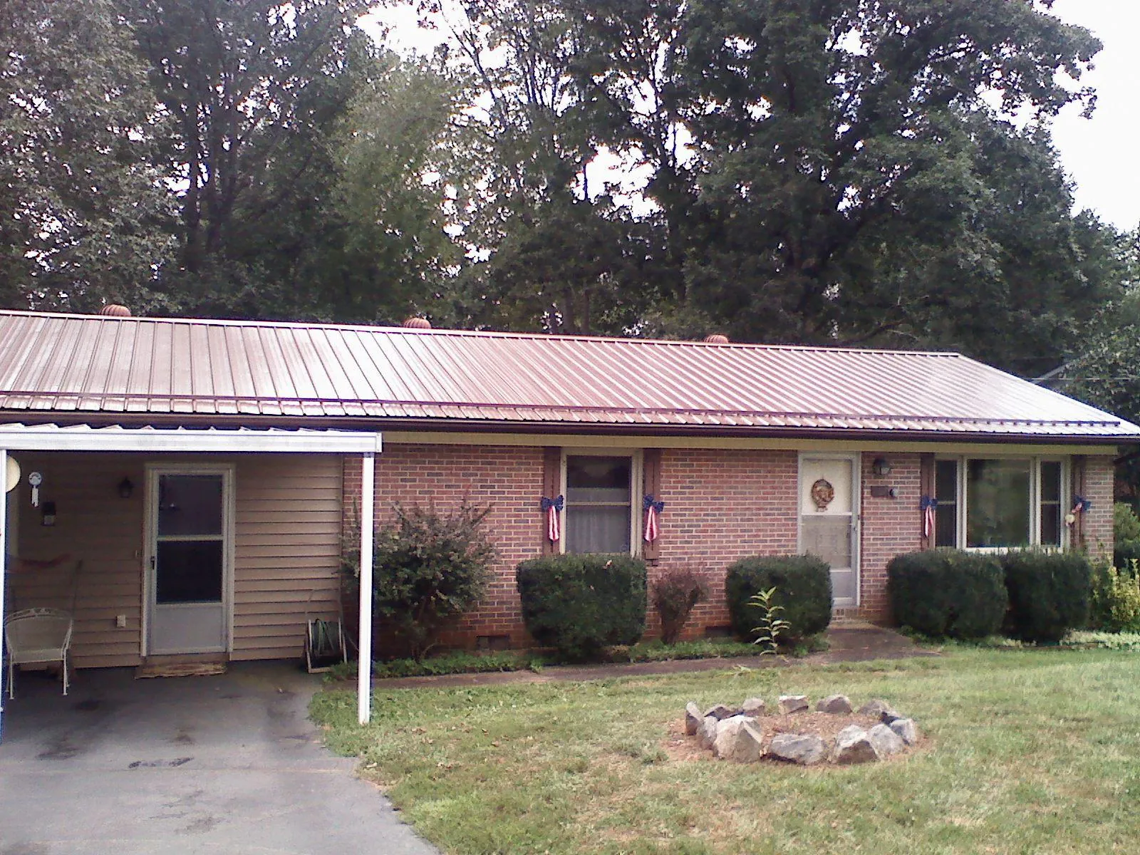 Bronze metal roof and carport on a brick ranch home — Roof Repair work by our crew in Burley